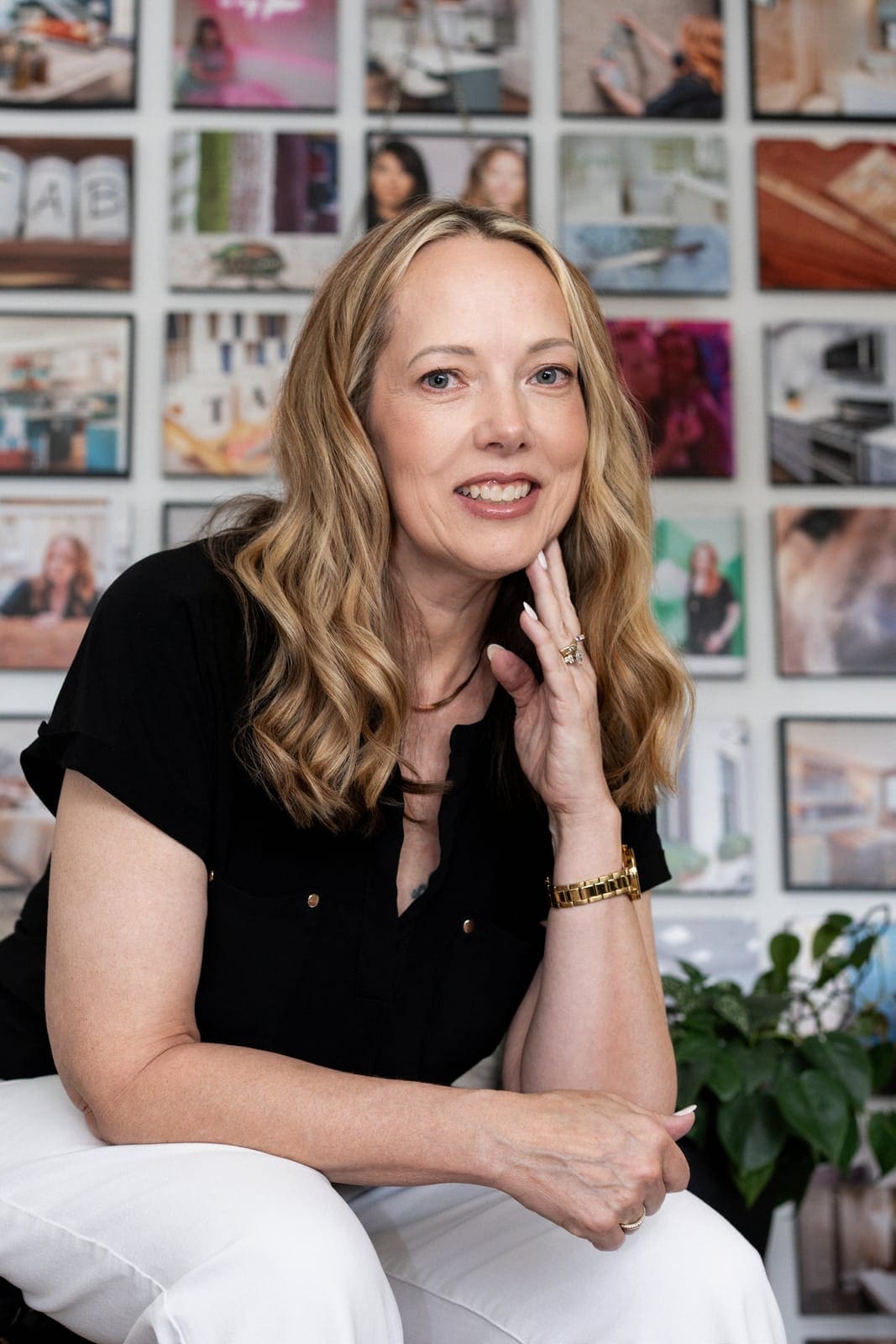 Trish Bonney, founder and principal interior designer of TAB Interior Designs, in front of the studio photo wall
